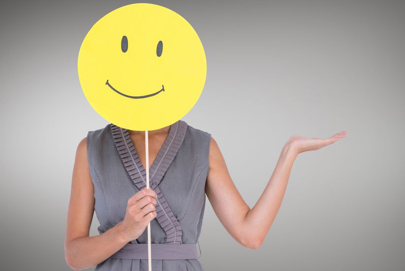 Imagen: mujer que cubre su cara con emoji de cara feliz