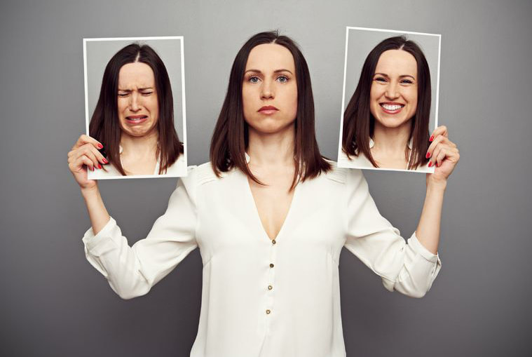 Mujer sosteniendo dos diferentes fotos de ella misma 